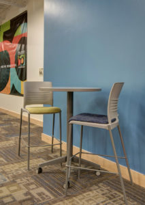 Common area with high table and stools at the CMC Morgridge Commons
