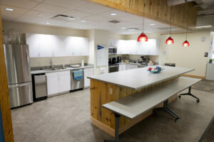 The Kitchen at Colorado Mountain College - Morgridge Commons, a large kitchen complete with fridge, stove, dishwasher, sink and counter.